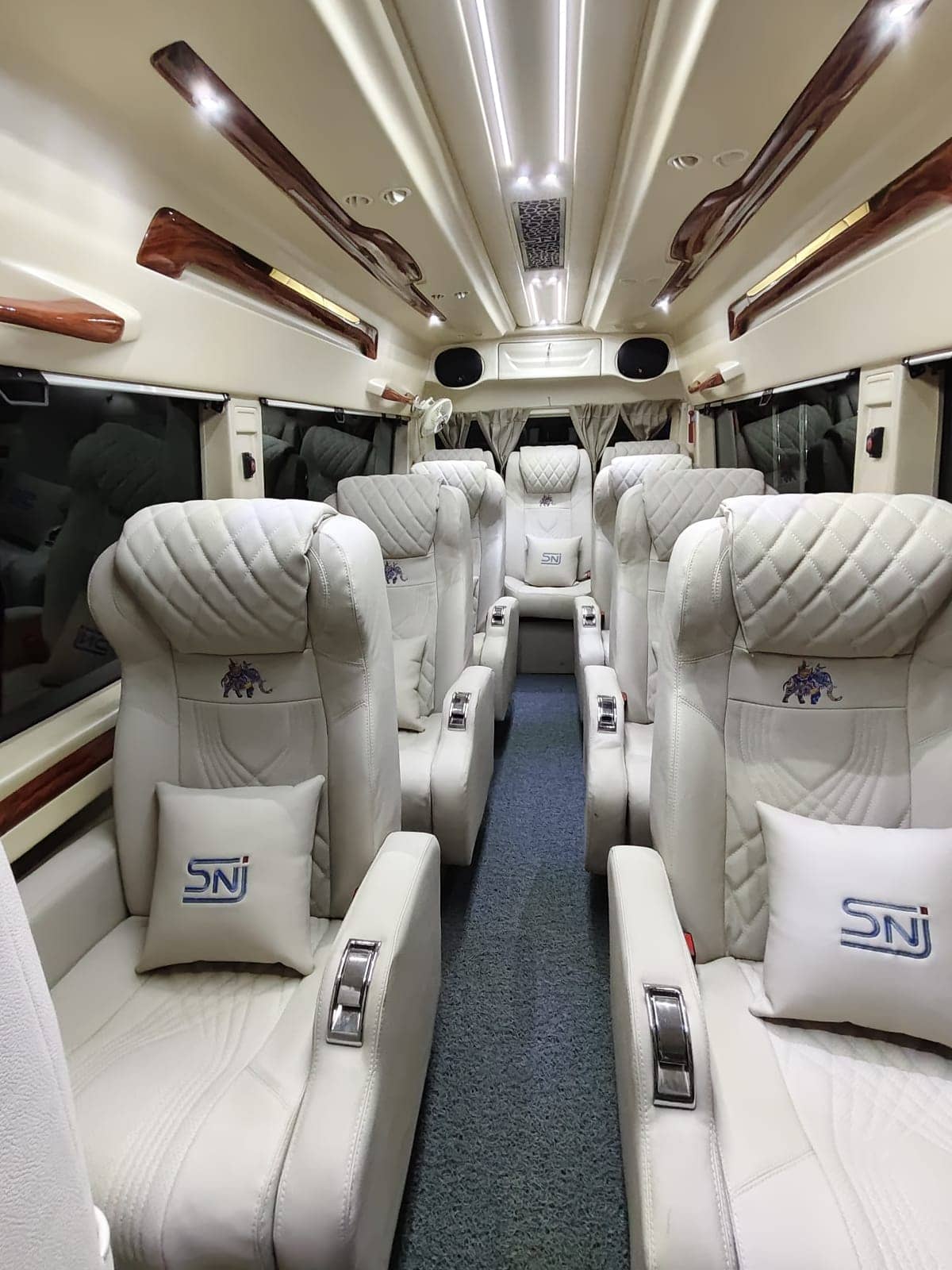Cream quilted recliner seats and wood trim inside a luxury Tempo Traveller