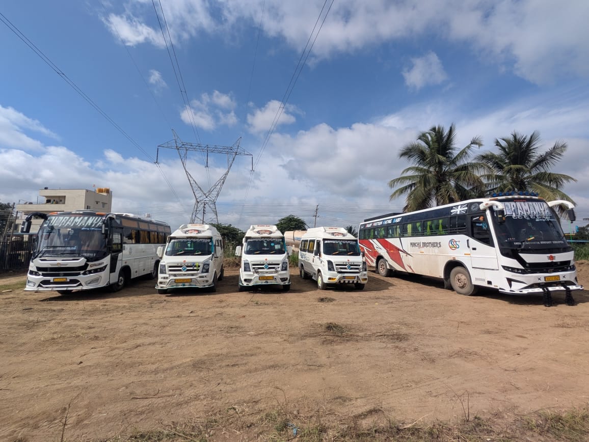 The Sri Subramanyaswamy Tours & Travels fleet lined up — Tempo Travellers, a mini coach and a tourist coach